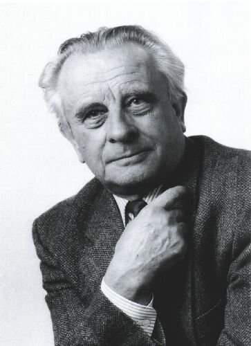 Schwarz-weiß-Foto eines Mannes mit grauem Haar und Anzug, der nachdenklich die Hand am Kinn hält