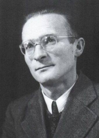 Heinrich Hintenberger Schwarz-weiß-Porträt eines Mannes in Anzug, Krawatte und weißem Hemd vor dunklem Hintergrund.