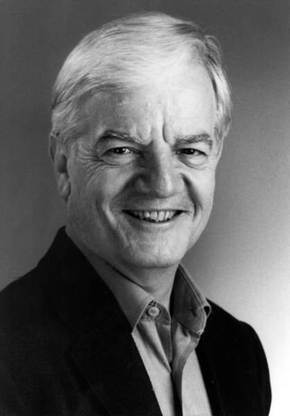 Black and white portrait of a man wearing a suit jacket and collared shirt.