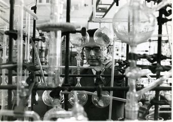 Heinrich Wänke bei der Extraktion von Edelgasen am MPI für Chemie. Bild: MPI für Chemie. Komplexes Labor mit zahlreichen Glasapparaturen, ein Mensch ist teilweise durch die Geräte sichtbar.