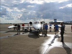 Flugzeug und Menschen vor dem Hangar