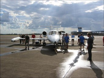 Airplane and people infront of the hangar.