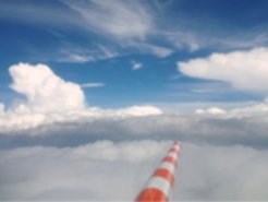 Vom Cockpit des Forschungsflugzeugs HALO aus erkennt man in Flugrichtung auf die Wolken eine Sonde zur Vermessung der Luftströmung.