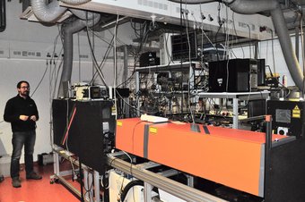 Person steht neben Messinstrumenten im Labor.