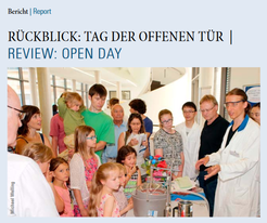 Newsletter front page 3/2016. People gather around a science demonstration table.