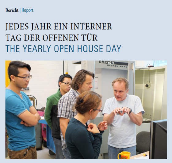Newsletter front page 1/2013. Individuals engaged in conversation in a workshop, with a machine in the background.