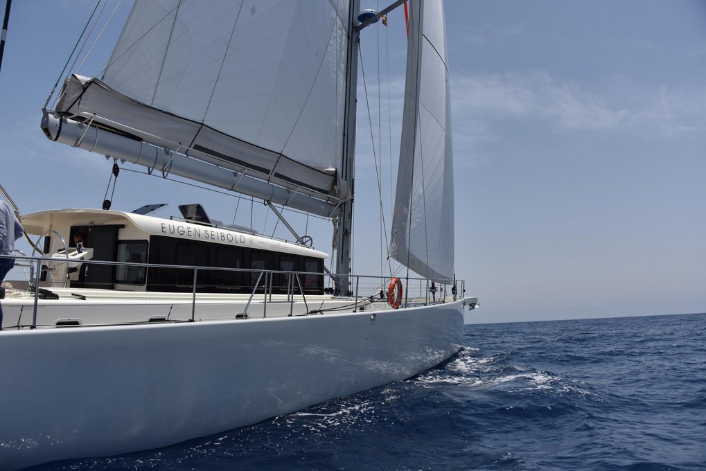 White sailing yacht named Eugen Seibold on the open sea with sails raised.