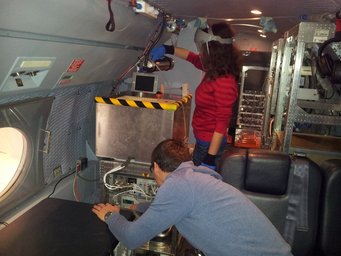 Personen die während einer Kampagne im Flugzeug an Instrumenten arbeiten.