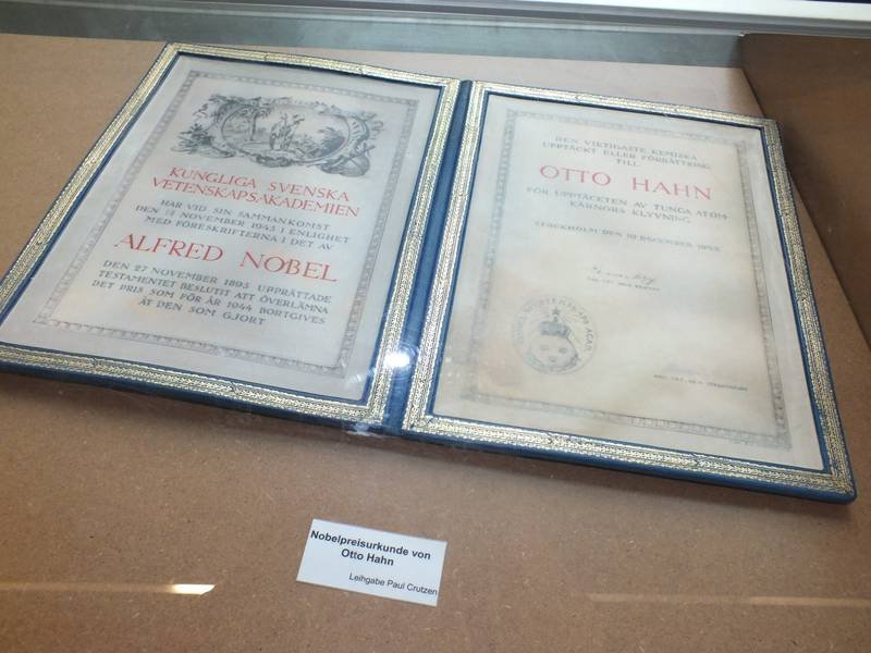 Nobel Prize certificate awarded to Otto Hahn displayed in a showcase.