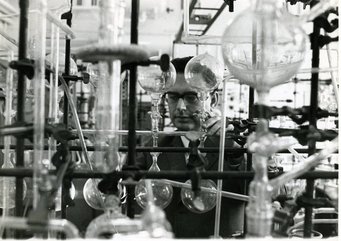 Heinrich Wänke extracting inert gases in Mainz. Source: MPI for Chemistry. Various laboratory glass apparatuses including flasks and tubes set up on metal stands in a scientific research environment.