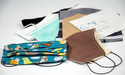 Collection of fabric masks, including a colorful bird-patterned mask and plain masks, with fabric swatches.