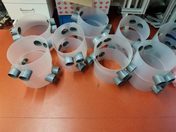 Kunststoffbehälter mit mehreren grauen Anschlüssen auf rotem Boden.