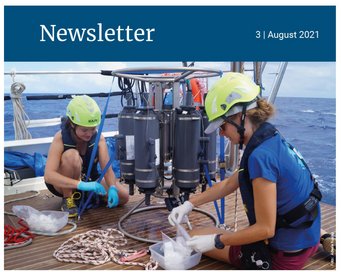 Scientists prepare sampling containers beside marine instruments on a vessel.