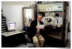 Dr. Klaus Peter Jochum in seinem Labor im alten Gebäude des Max-Planck-Instituts für Chemie in den 1990er Jahren. Mithilfe des Spark Source Massenspektrometers, das im Hintergrund zu sehen ist, analysierte Jochums Forschungsteam damals vor allem Ozeaninselbasalte, wie diejenigen von Hawaii, aber auch noch Mondproben.