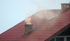 Roof view (red tiles), chimney, rising, light-colored smoke