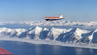 Blick auf das Forschungsflugzeug Polar 5 über der vereisten Landschaft der Arktis. Flugzeug Polar 5 über vereister Landschaft.