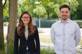 Looking forward to taking part in this year's Nobel Laureate Meeting: atmospheric chemist Clara Nussbaumer and polymer scientist Tilmann Herberger. Not in the picture: Shoupeng Cao. A woman in a blazer and a man in a shirt stand side by side outdoors.