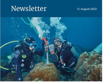 Two divers are conducting research on coral reefs using specialized equipment.