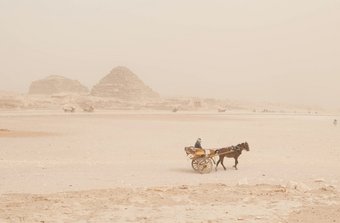 Um die schlimmsten Wetterereignisse im östlichen Mittelmeerraum und Nahen Osten abzuwenden, hält eine Gruppe  internationaler Wissenschaftler:innen sofortige und effektive Klimaschutzmaßnahmen für dringend erforderlich. Pyramiden, Ägypten, Staub, Karre mit Mann und Pferd