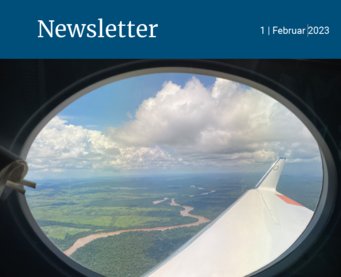 Aerial view on the brasilian rainforest through airplane window: wing, clouds, green terrain, and river visible.