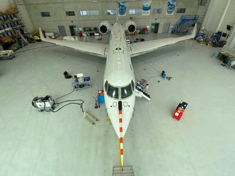 Preparing the HALO research aircraft in the hangar in Oberpfaffenhofen for the measurement campaign: Clearly visible are inlet openings for the measuring equipment on the upper side of the fuselage of the aircraft. HALO in Hangar from above