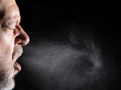 Hustender, älterer Mann. Viele ansteckende Krankheiten wie Erkältung, Grippe, Covid-19 aber auch Masern und Tuberkulose werden beim Sprechen, Niesen oder Husten von Mensch zu Mensch übertragen.