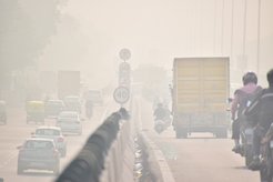 Autos auf einer Straße bei dichter Luftverschmutzung.
