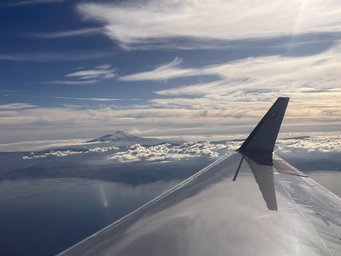 HALO-Testflug über Sizilien mit Sicht auf den Ätna, bevor die Expedition Richtung Australien startete. Tragflügel des Forschungsflugzeugs Halo in der Luft, über den Wolken, blauer Himmel, Schleierwolken