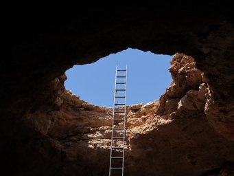 Descend into the depths: the entrance to a cave in the Arabian Desert. Descend into the depths: the entrance to a cave in the Arabian Desert.