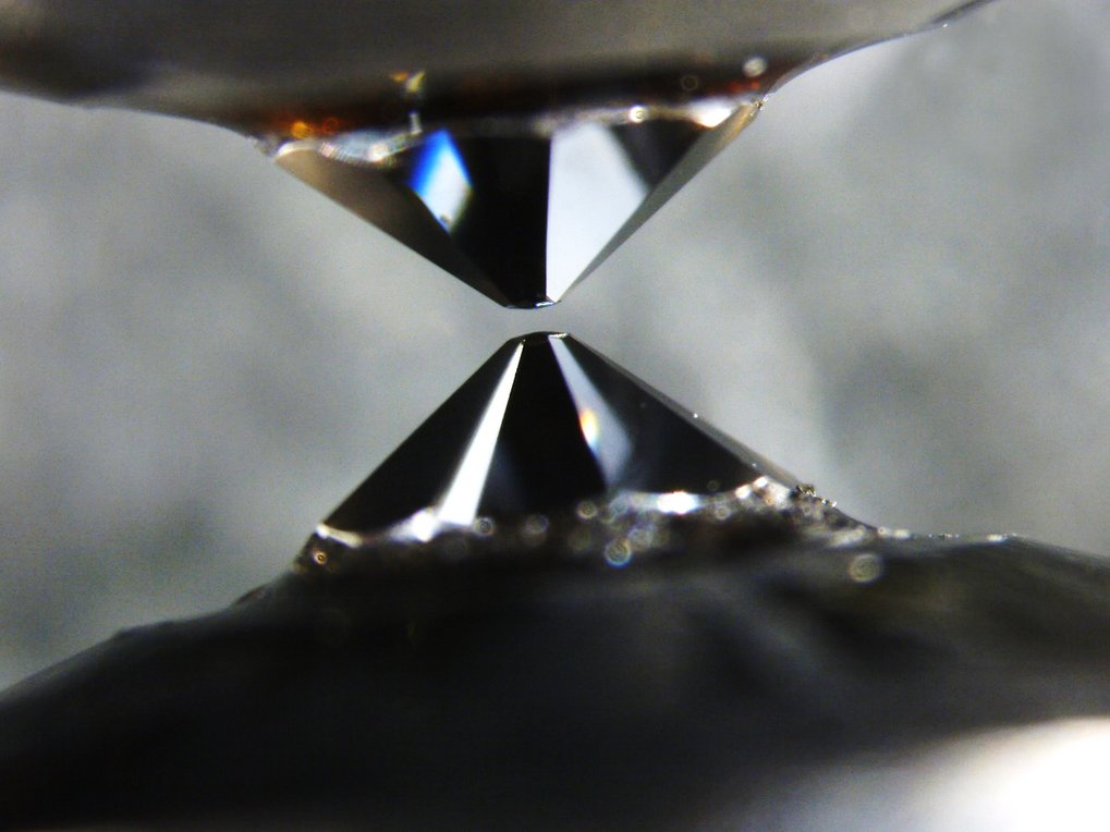 Two opposing diamond tips in close proximity, creating a high-pressure environment.