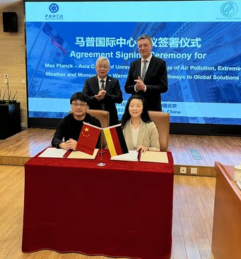 Following the signing of the agreement for the MAC Air Centre. From left: Hang Su, Director of the State Key Laboratory of Atmospheric Environment and Extreme Meteorology at the Institute of Atmospheric Physics of the CAS; CAS President Hou Jianguo; Max Planck Society President Patrick Cramer; and Yafang Cheng, Director of the Department of Aerosol Chemistry at the Max Planck Institute for Chemistry. Signing ceremony with Chinese and German flags on the table.