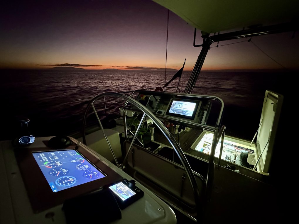 Segelbootsteuerung bei Sonnenuntergang mit beleuchteten Instrumenten.